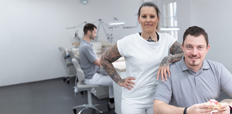 Zahnärztin und Zahntechniker arbeiten zusammen im Labor