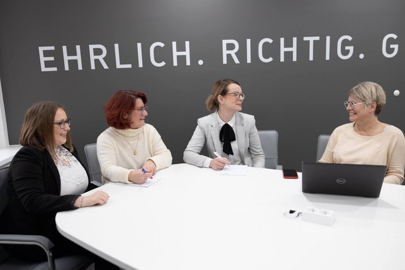 ZMV Team sitzt gemeinsam am Tisch für eine Besprechung 