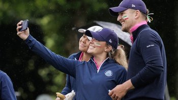Drei Golfer posieren lächelnd für ein Selfie auf dem Golfplatz, im Hintergrund sind grüne Bäume zu sehen.