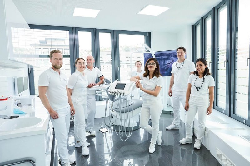 Großes Team aus Zahnärzten versammelt im Behandlungsraum