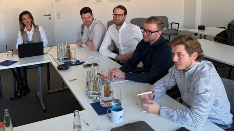 Zahnärzte sitzen um einen Tisch und unterhalten sich